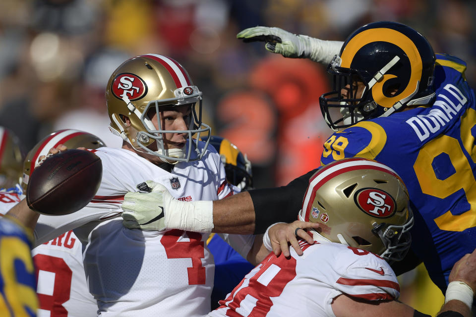 Los Angeles Rams defensive end Aaron Donald, right, puts pressure on San Francisco 49ers quarterback Nick Mullens during the first half in an NFL football game Sunday, Dec. 30, 2018, in Los Angeles. (AP Photo/Mark J. Terrill)