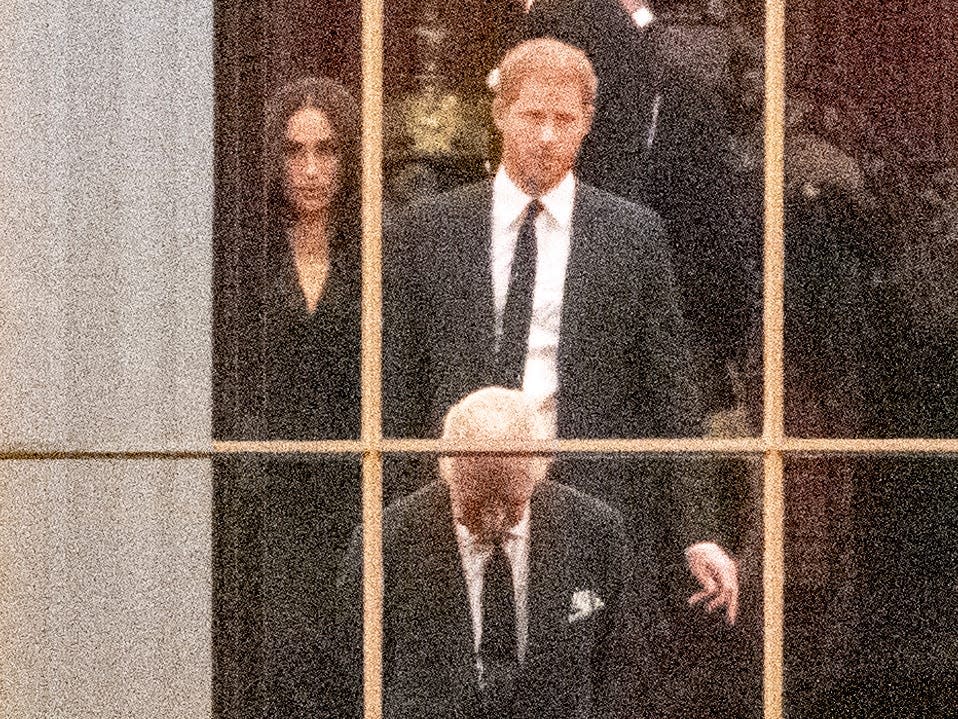 Meghan Markle, Prince Harry, and King Charles III through a window of Buckingham Palace on September 13.