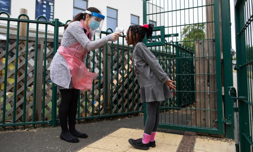 A staff member takes a child’s temperature at the Harris Primary Academy Shortlands school, London.