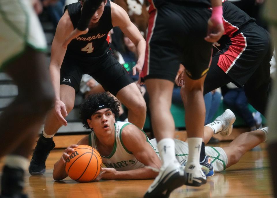 St. Mary's Knights guard Styles Phipps (1) scrambles for a loose ball against the Brophy Prep Broncos at St. Mary's High School gym on Jan. 3, 2024.