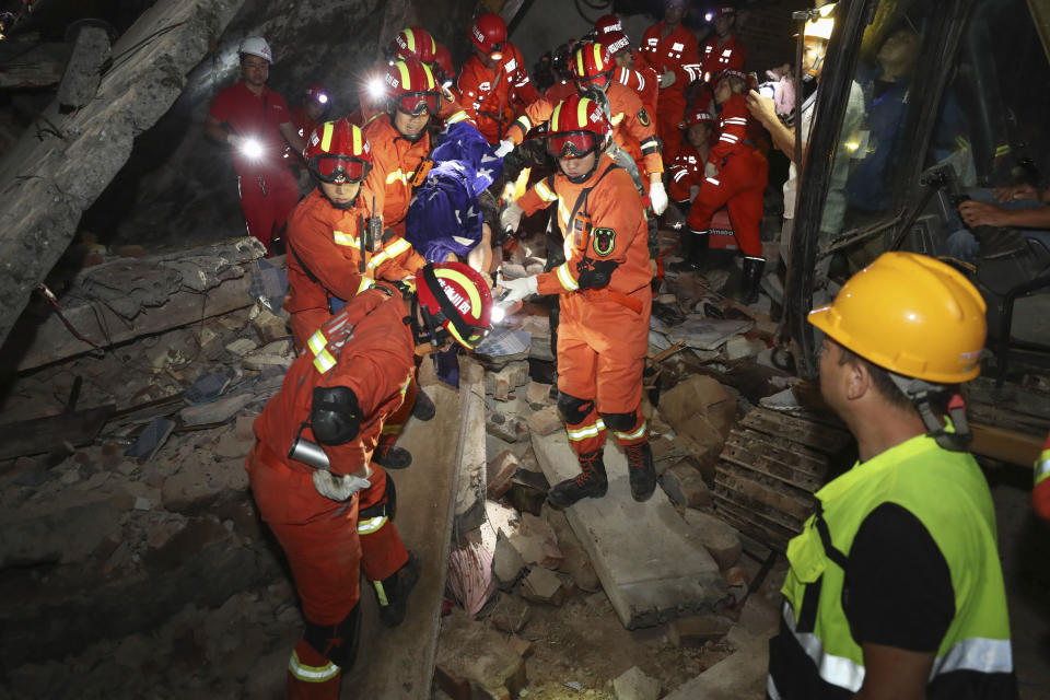 In this photo released by Xinhua News Agency, rescue workers carry out a person from a collapsed building following a strong earthquake at Putao village of Shuanghe town in Changning County of Yibin City, southwest China's Sichuan Province, Tuesday, June 18, 2019. (Zhuang Ge'er/Xinhua via AP)