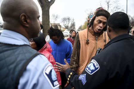 A protester argues with a police officer in front of a north Minneapolis police precinct during a protest in response of Sunday's shooting death of Jamar Clark by police officers in Minneapolis, Minnesota, November 18, 2015. REUTERS/Craig Lassig