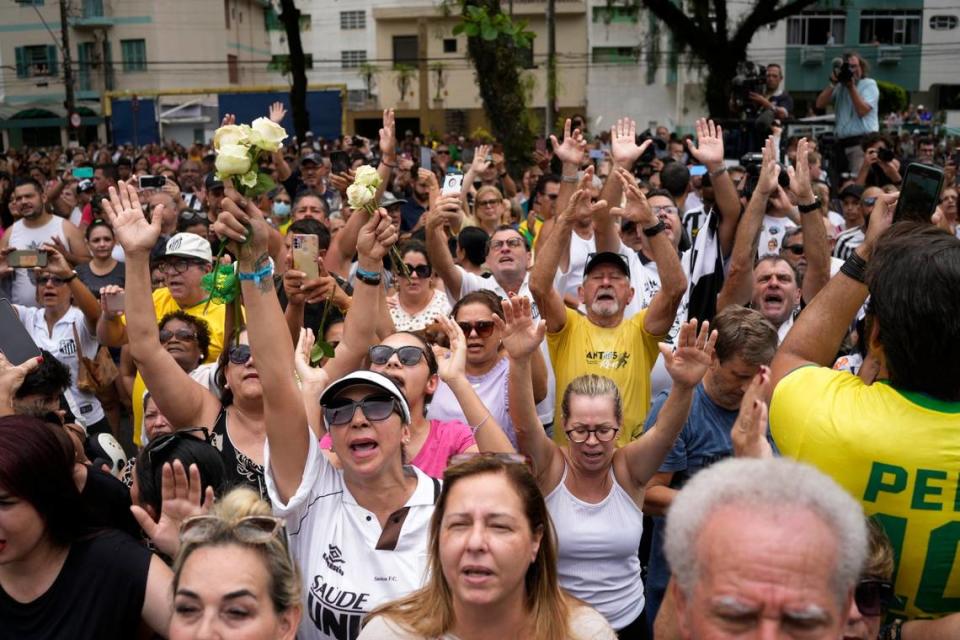 Personas expresan sus emociones afuera de la casa de la madre de Pelé durante su cortejo fúnebre desde el estadio Vila Belmiro hasta el cementerio en Santos, Brasil, el martes 3 de enero de 2023.