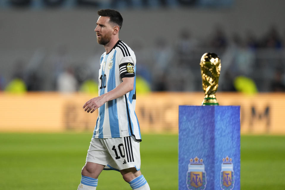 Argentina's Lionel Messi walks past the FIFA World Cup trophy prior to an international friendly soccer match against Panama in Buenos Aires, Argentina, Thursday, March 23, 2023. (AP Photo/Natacha Pisarenko)