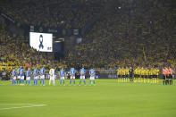 Team players and referees, right, stand during a minute of silence for the victims of the terrorist attack at the Olympic Games in Munich in 1972, prior the German Bundesliga soccer match between Borussia Dortmund and TSG 1899 Hoffenheim in Dortmund, Germany, Friday, Sept. 2, 2022. Eleven athletes from Israel and one German police officer were killed 50 years ago in the terrorist attack during the 1972 Olympic Games in Munich. (AP Photo/Martin Meissner)
