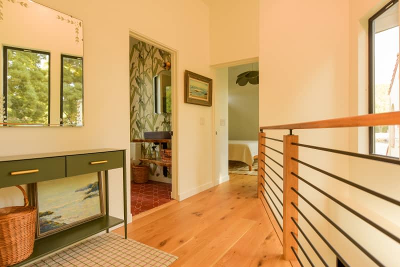 Honey stained wood floors seen in upstairs hallway.