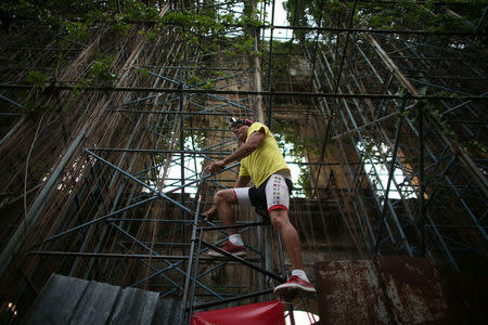 Felix Guirola, 52, rides a homemade bike with an advertising banner in Havana, Cuba, July 20, 2016. REUTERS/Alexandre Meneghini