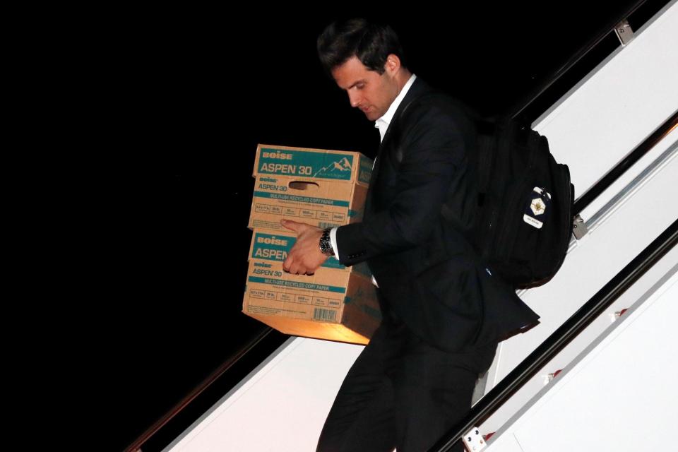 President Donald Trump' personal aide John McEntee carries boxes as he returns with Trump aboard Air Force One after travel to five countries in Asia, to Joint Base Andrews, Maryland, U.S. November 15, 2017.