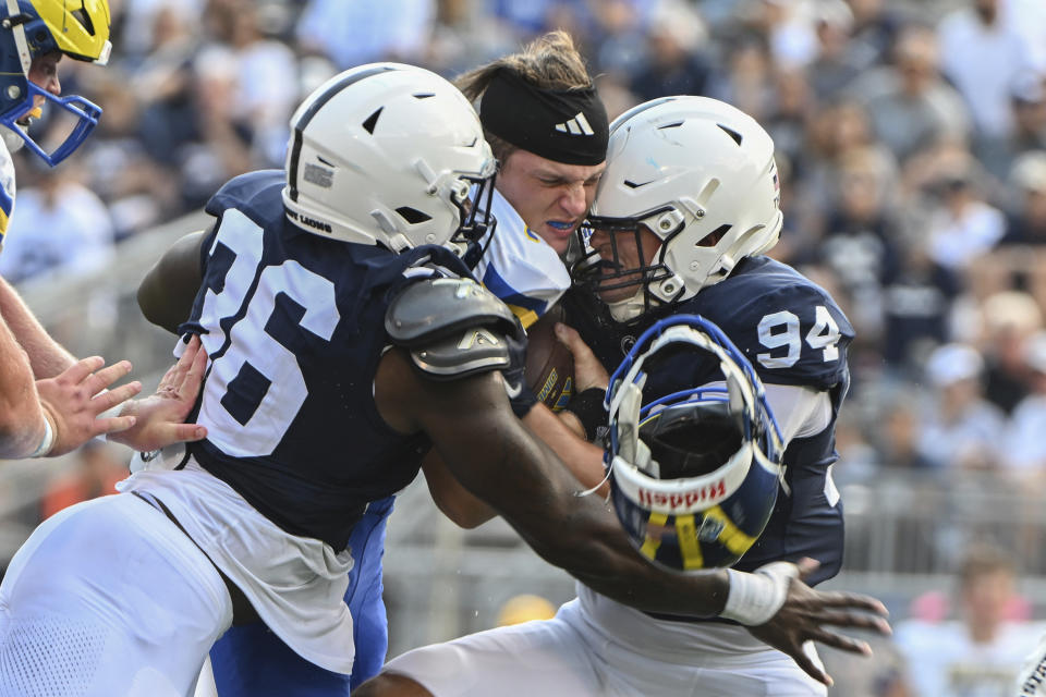 Delaware quarterback Zach Marker (3) loses his helmet as Penn State defenders Zuriah Fisher (36) and Jake Wilson (94) tackle him during the second half of an NCAA college football game, Saturday, Sept. 9, 2023, in State College, Pa. (AP Photo/Barry Reeger9