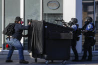 A protestor faces off with two police officers using less-lethal ammunition in their weapons, Thursday, May 28, 2020, in St. Paul, Minn. Protests over the death of George Floyd, a black man who died in police custody Monday, broke out in Minneapolis for a third straight night. (AP Photo/John Minchillo)