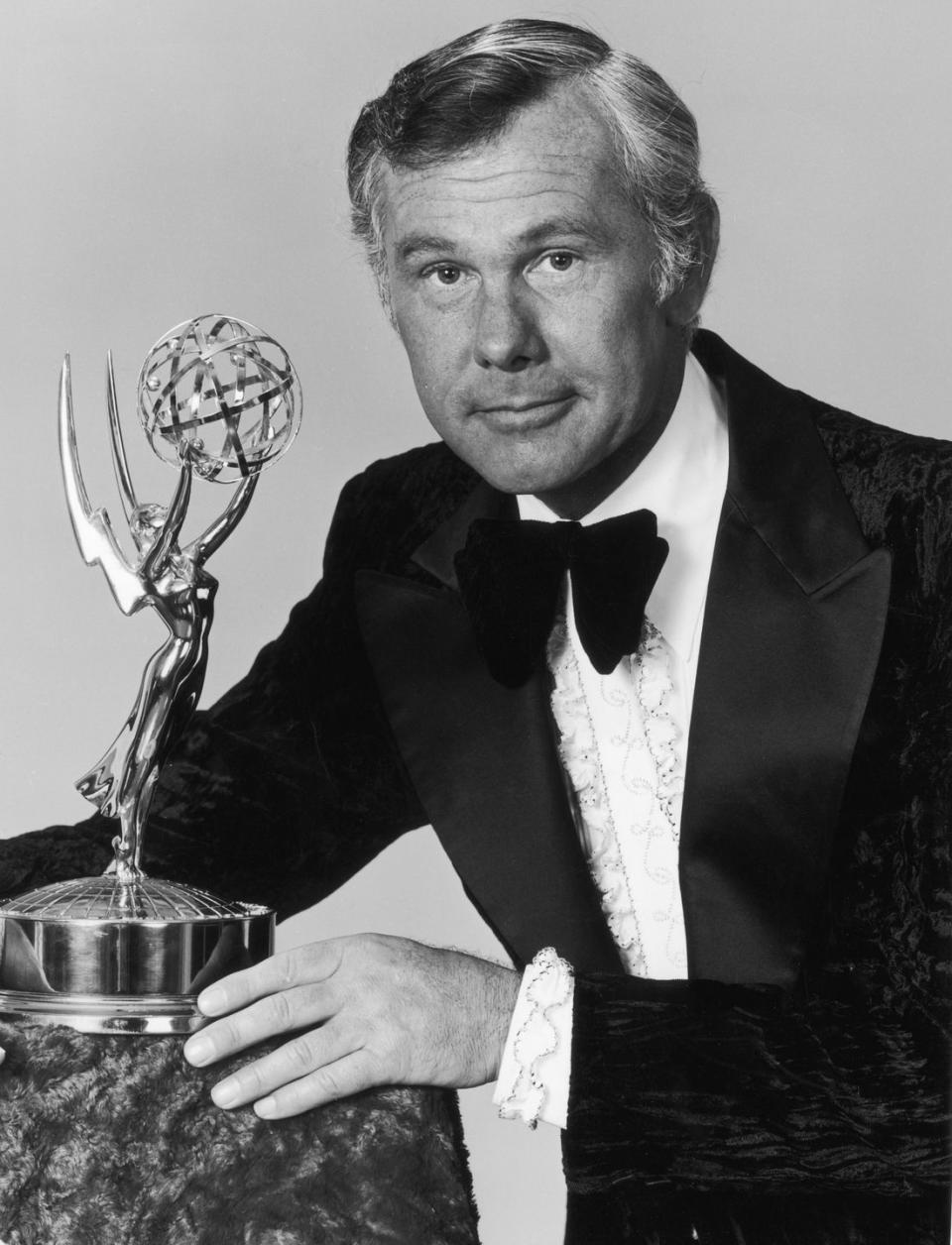 <p>Talk show host Johnny Carson poses next to his Emmy statue. Carson hosted the ceremony four times during his career. </p>