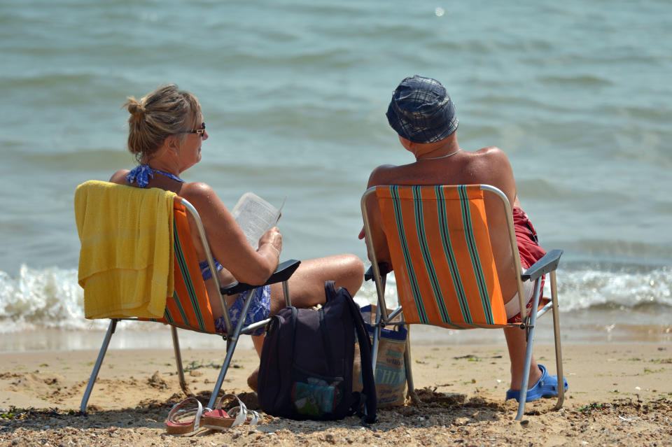 A couple relaxes on the beach at Clacton-on-Sea in Essex. (PA Images)