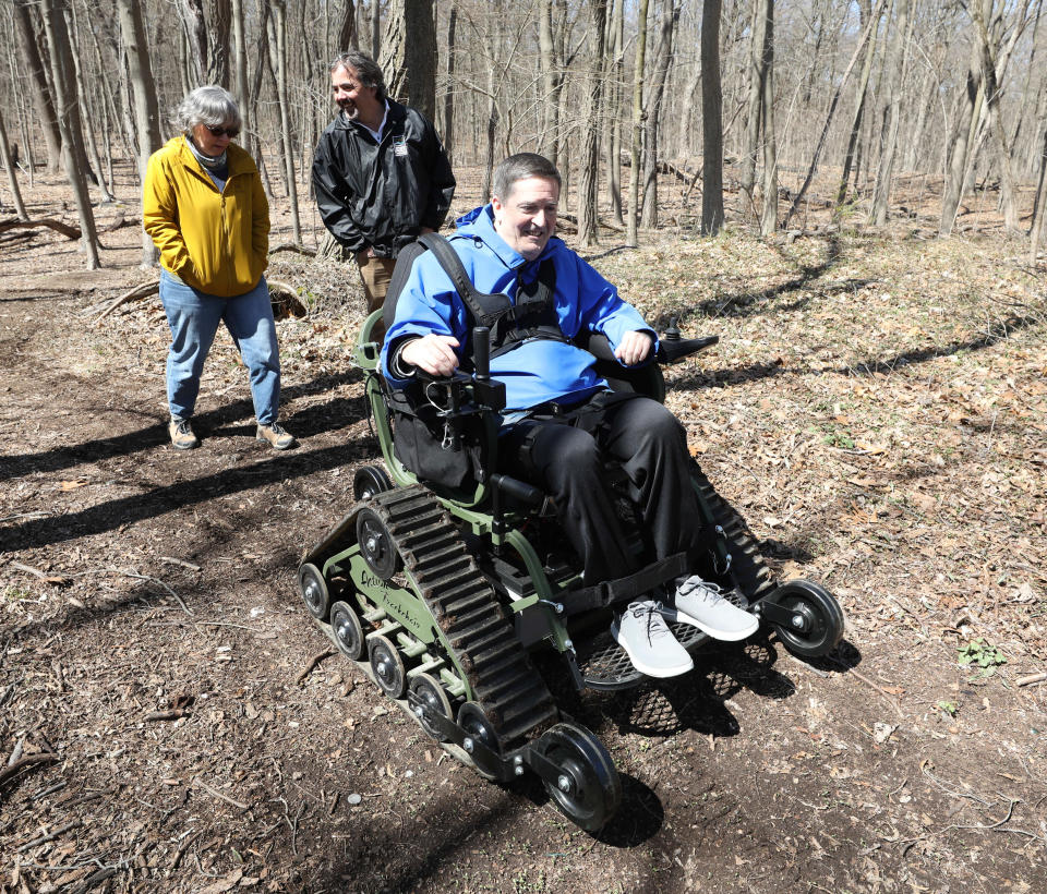 Kevin Lange from Pleasantville, a pilot program participant in the Westchester Parks Foundation All-Terrain Trackchair program, navigates the trails with volunteer Nancy Rosenbach and Adam Lippman, a volunteer coordinator at Saxon Woods Park in White Plains, March 29, 2023.
