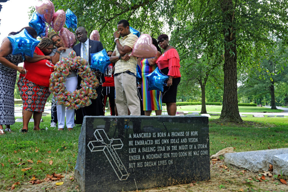 FILE - In this Friday, Aug. 9, 2019 file photo, Lesley McSpadden, the mother of Michael Brown, prays with a group from Rainbow of Mothers, before placing a large wreath at her son's grave on the fifth anniversary of this death, at St. Peter's Cemetery in St. Louis. At left is Samaria Rice, the mother of Tamir Rice, who was killed by police in 2014 in Ohio. At center is Ben Crump, her attorney, and at right, her husband, Louis Head. (Laurie Skrivan/St. Louis Post-Dispatch via AP)