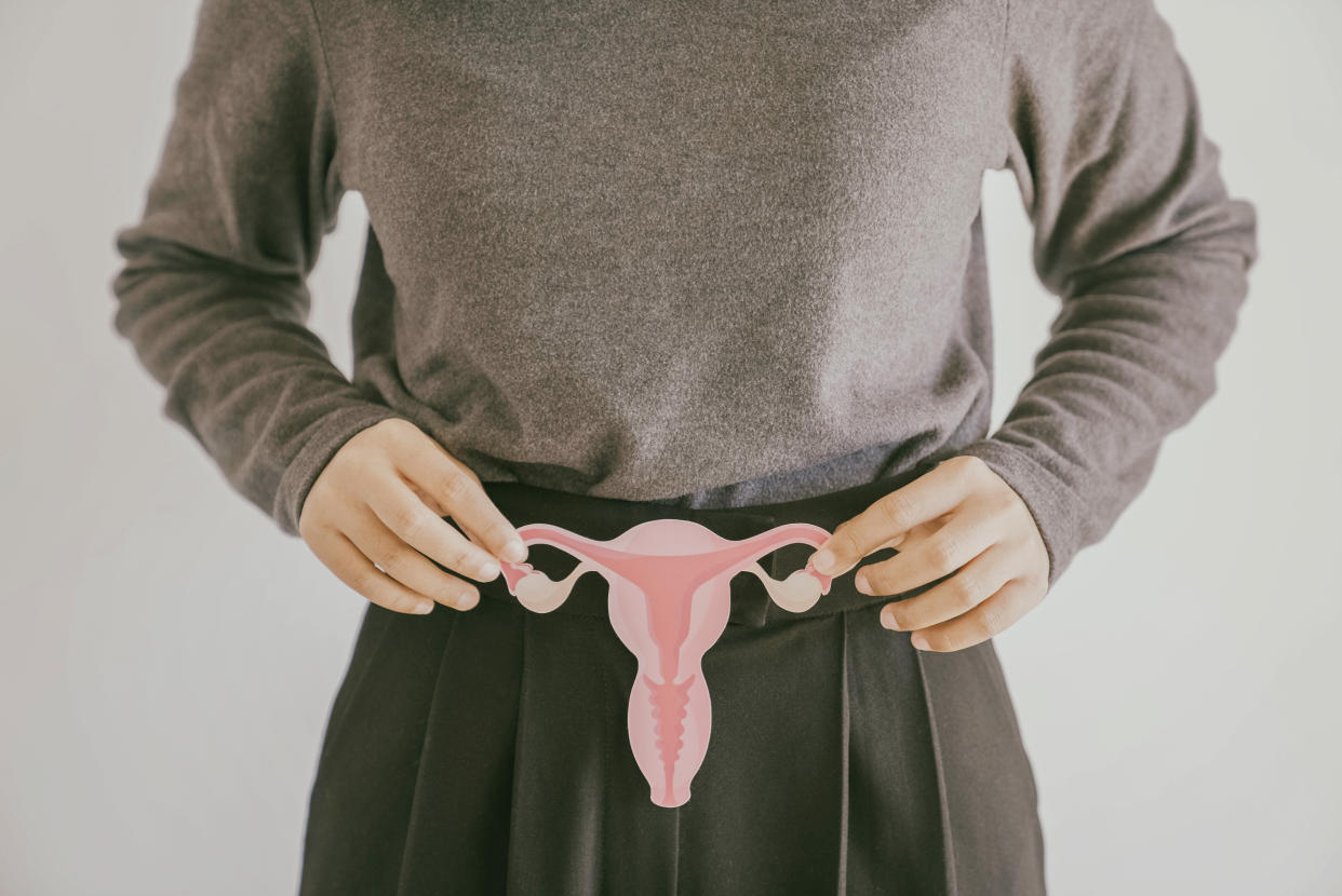 Woman hands holding uterus, female reproductive system , woman health, PCOS, gynecologic and cervix cancer concept