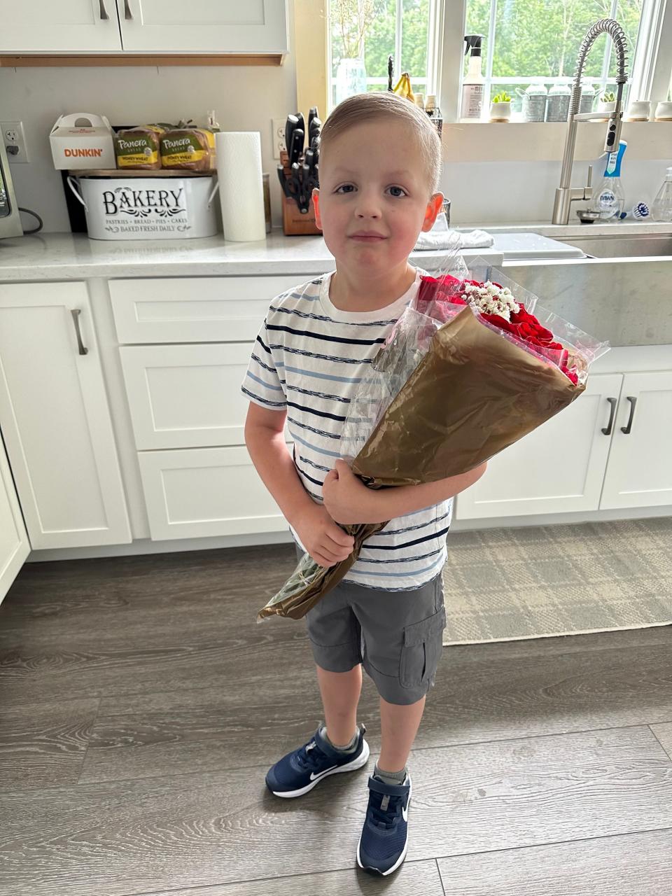 Jase Russell enjoying an evening out with his family holding flowers. The young boy who will be in first grade in September loves trains and watching documentaries about them. July 21, 2023.