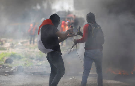 Palestinian demonstrators prepare molotov cocktail during clashes with Israeli troops at a protest against Trump's decision on Jerusalem, near Ramallah, in the occupied West Bank March 9, 2018. REUTERS/Mohamad Torokman