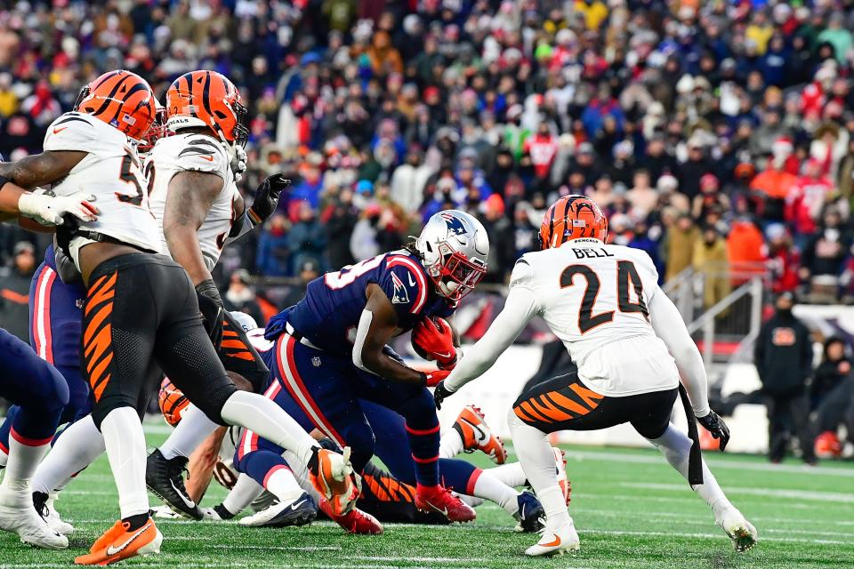 Patriots running back Rhamondre Stevenson (38) is tackled by a host of Bengals defenders during the second half of Saturday's game at Gillette Stadium in Foxboro.