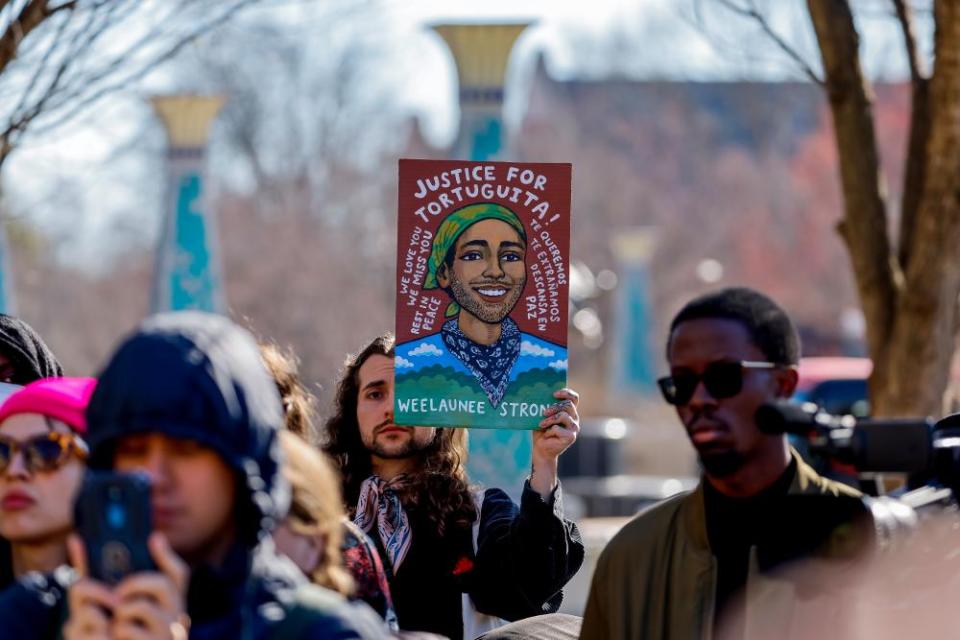 A person holds an illustration of the slain environmental activist at a news conference in February.