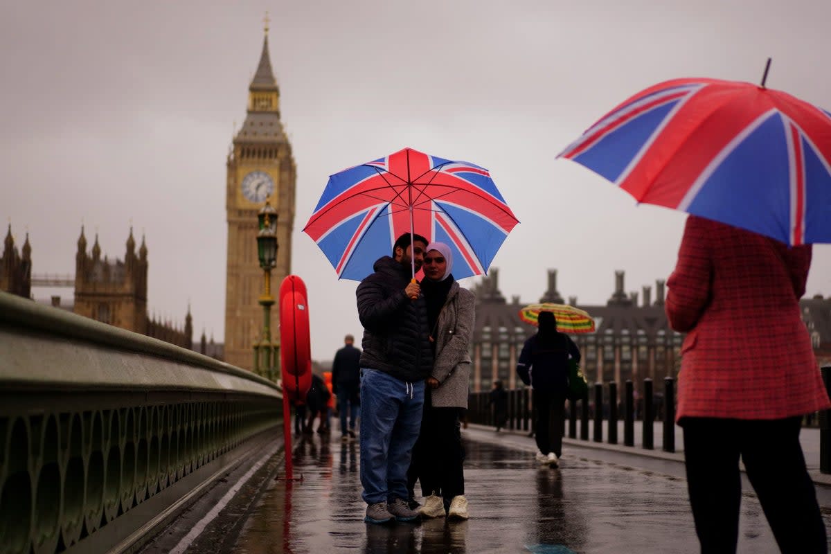 Londoners walk past Big Ben in the rainy weather (File picture)  (PA)