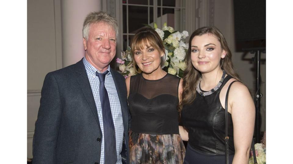 Lorraine Kelly and her husband Steve against the backdrop of white flowers