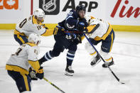 Winnipeg Jets' Pierre-Luc Dubois (80) gets past Nashville Predators' Colton Sissons (10) and Dante Fabbro (57) during the second period of NHL hockey game action in Winnipeg, Manitoba, Saturday, Oct. 23, 2021. (Fred Greenslade/The Canadian Press via AP)