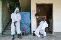 Men wear protective suits before joining a funeral of a person who died due to coronavirus disease (COVID-19) in Dhaka