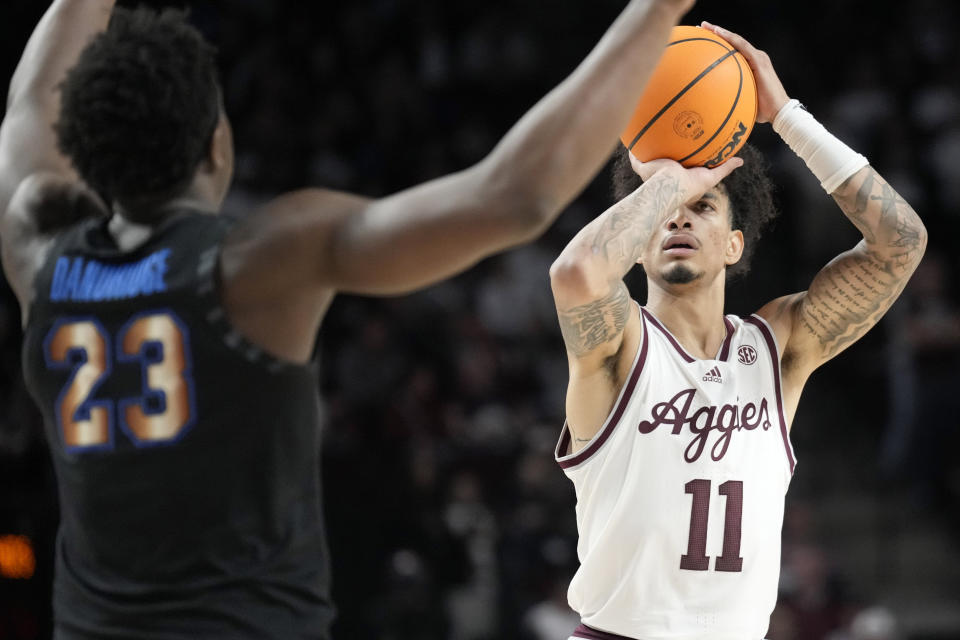 Texas A&M forward Andersson Garcia (11) looks to shoot a 3-point basket over Memphis forward Malcolm Dandridge (23) during the first half of an NCAA college basketball game Sunday, Dec. 10, 2023, in College Station, Texas. (AP Photo/Sam Craft)