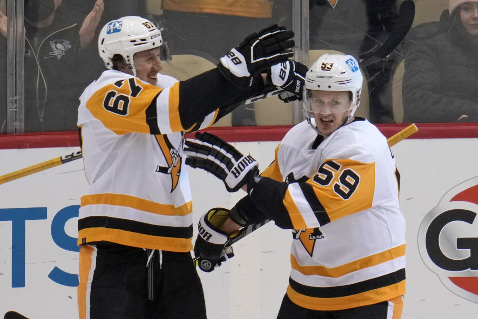 Pittsburgh Penguins' Rickard Rakell (67) celebrates his goal against the Buffalo Sabres with Jake Guentzel (59) during the first period of an NHL hockey game in Pittsburgh, Saturday, Dec. 10, 2022. (AP Photo/Gene J. Puskar)