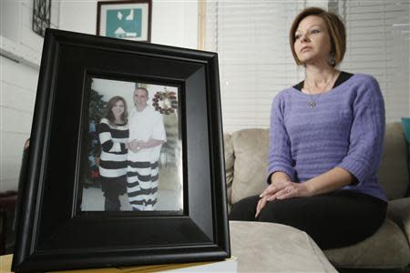 Kelly Muscolino, whose husband Mike is a prisoner serving 20 years for armed robbery, poses in front of a photo of the two of them at their home in Philadelphia, Mississippi January 15, 2014. REUTERS/Thomas Wells