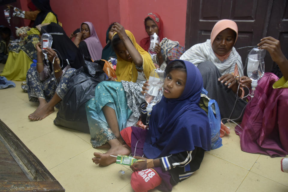 Ethnic Rohingya women and children sit on the floor upon arrival at a temporary shelter after their boat landed in Pidie, Aceh province, Indonesia, Monday, Dec. 26, 2022. A second group in two days of weak and exhausted Rohingya Muslims landed on a beach in Indonesia's northernmost province of Aceh on Monday after weeks at sea, officials said. (AP Photo/Rahmat Mirza)