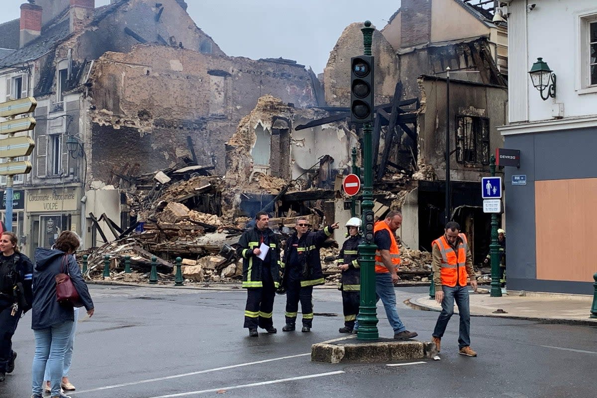 Emergency personnel survey the scene of a burnt out building in France following rioting   (AFP via Getty Images)