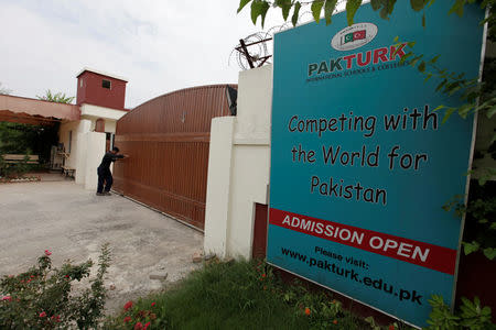A man closes the main gate of PakTurk International Schools and Colleges in Islamabad, Pakistan, August 2, 2016. REUTERS/Faisal Mahmood