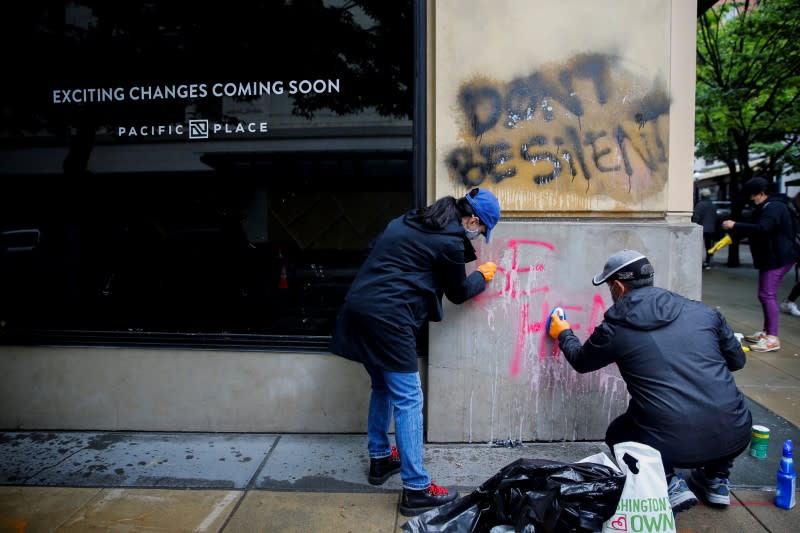 Community members help clean debris and graffiti the morning after a rally against the death in Minneapolis police custody of George Floyd, in Seattle