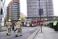 Firefighters at the scene in New Providence Wharf in London, Friday, May 7, 2021. Firefighters have tacked a blaze in a London apartment tower that has cladding similar to that used on a building where 72 people died in 2017. London Fire Brigade said about 125 firefighters tackled a fire on Friday that spread to three floors of a 19-story building in the city’s docklands. (Yui Mok/PA via AP)
