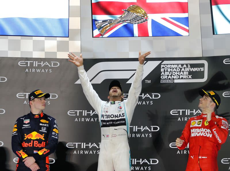 Lewis Hamilton de la escudería Mercedes celebra, en medio de Max Verstappen y de Charles Leclerc, tras ganar el Gran Premio de Fórmula 1 de Abu Dabi