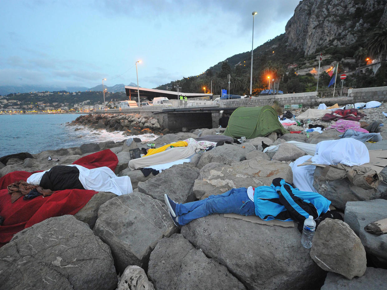 Migrants sleep by the sea yesterday in Ventimiglia, Italy, near the French border, which they have been barred from crossing: EPA