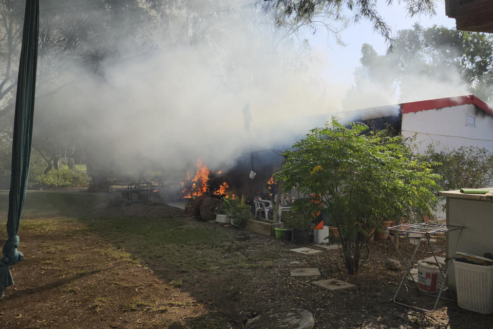 FILE - A house is on fire in the kibbutz of Kfar Azza, Israel, that Palestinians stormed from the Gaza Strip on Saturday, Oct. 7, 2023. Israel's military brought together a group of foreign correspondents Monday, Oct. 16, to screen a 40-minute reel of gruesome footage compiled from the Hamas attack last week. The screening came as Israel's military faces increasing pressure to back up their claims of atrocities committed by the militants. (AP Photo/Hassan Eslaiah, File)