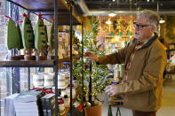 Rick Haase, owner of eight Patina gift shops, organizes store items Thursday, Nov. 2, 2023, in Woodbury, Minn. All signs point to a relatively solid holiday season for America’s small businesses. Yet, owners of these businesses appear to have a collective anxiety about the months ahead. (AP Photo/Abbie Parr)