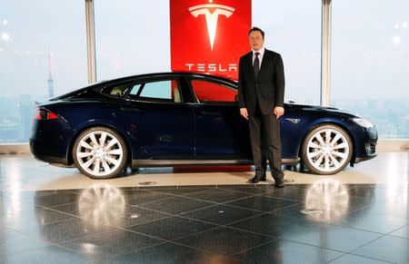 Tesla Motors Inc Chief Executive Elon Musk poses with a Tesla Model S electric car in Tokyo September 8, 2014. REUTERS/Toru Hanai