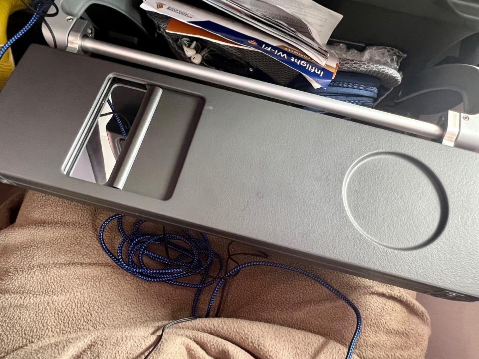 The tray table folded in half with a cupholder on the right and mirror on the left.