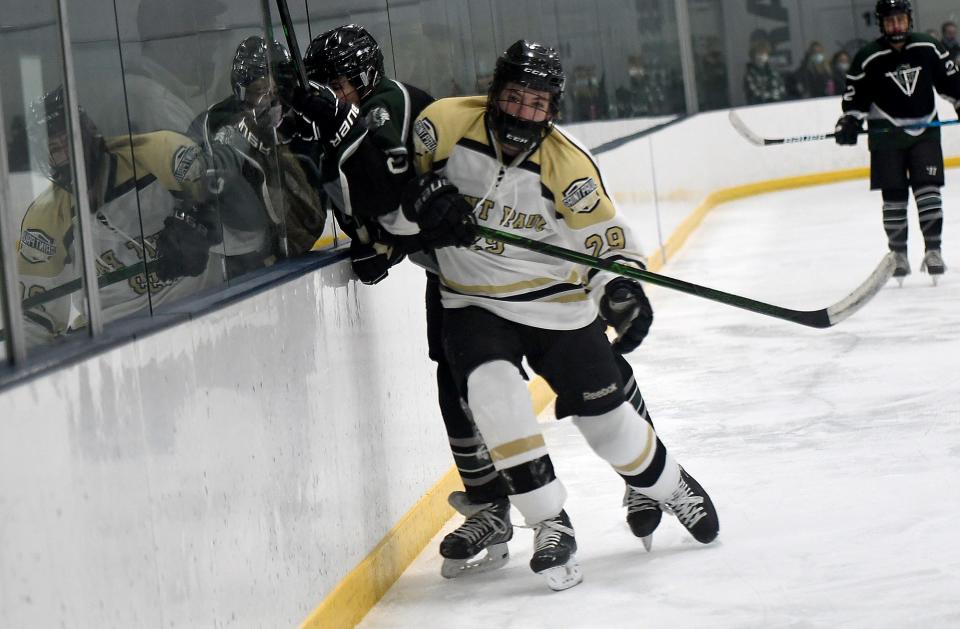 St. Paul's Chase Burdett checks Grafton's Cam Michaud into the boards during Wednesday's game