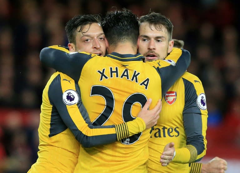 Arsenal's midfielder Mesut Ozil (L) celebrates scoring his team's second goal with Aaron Ramsey (R) and Granit Xhaka