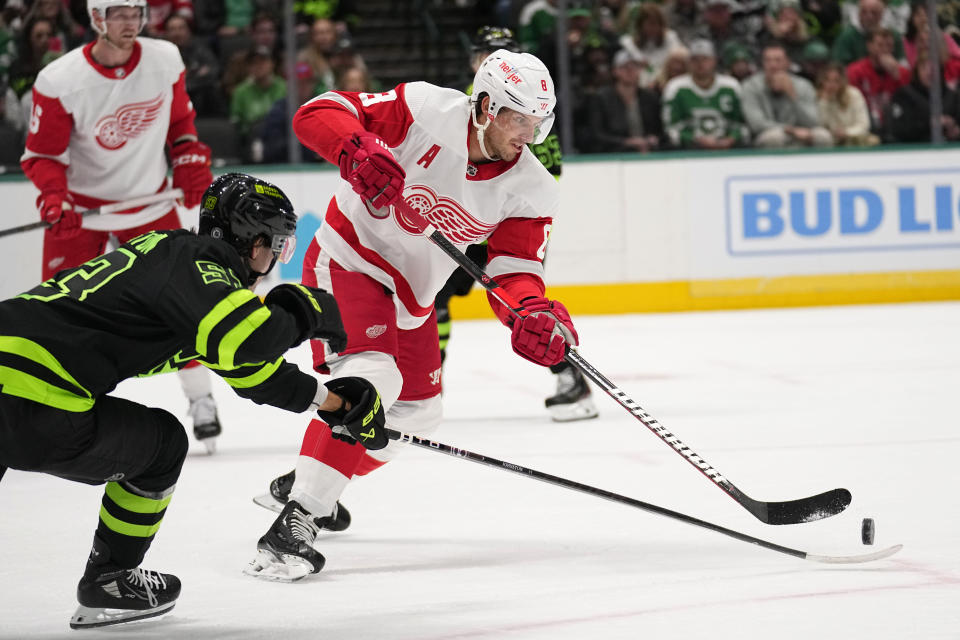 Detroit Red Wings defenseman Ben Chiarot moves to take control of the puck in front of Dallas Stars center Wyatt Johnston in the first period of an NHL hockey game in Dallas, Monday, Dec. 11, 2023. (AP Photo/Tony Gutierrez)