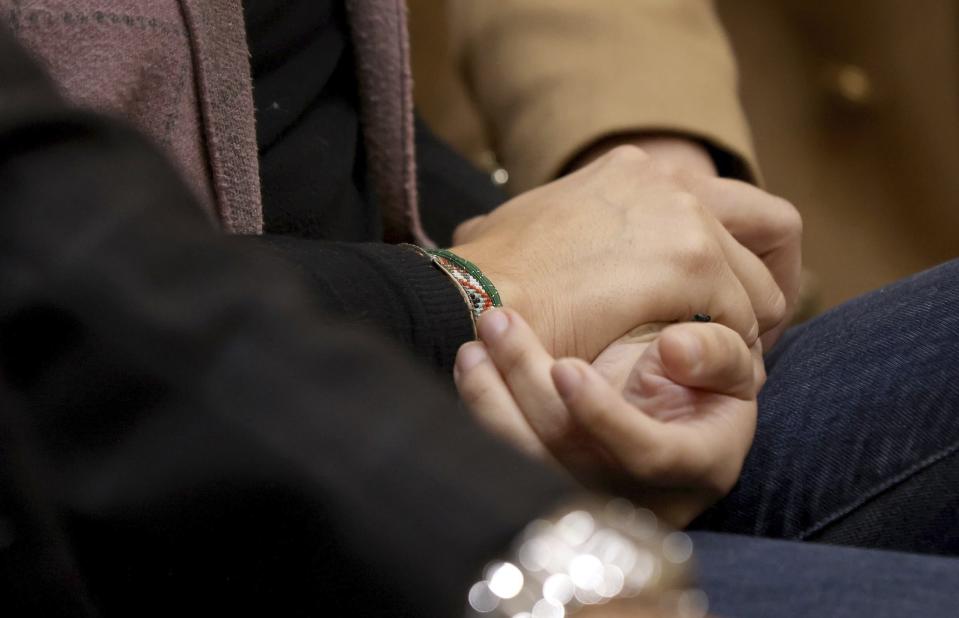 Pablo Lyle's family members hold hands as Judge Maria Tinkler Mendez ruled against a new trial for Lyle as he, his family, lawyers, and members of the media gathered in Courtroom 4-6 at the Richard E. Gerstein Justice Building in Miami, Fla. on Monday, Dec. 12, 2022. (Carl Juste/Miami Herald via AP)