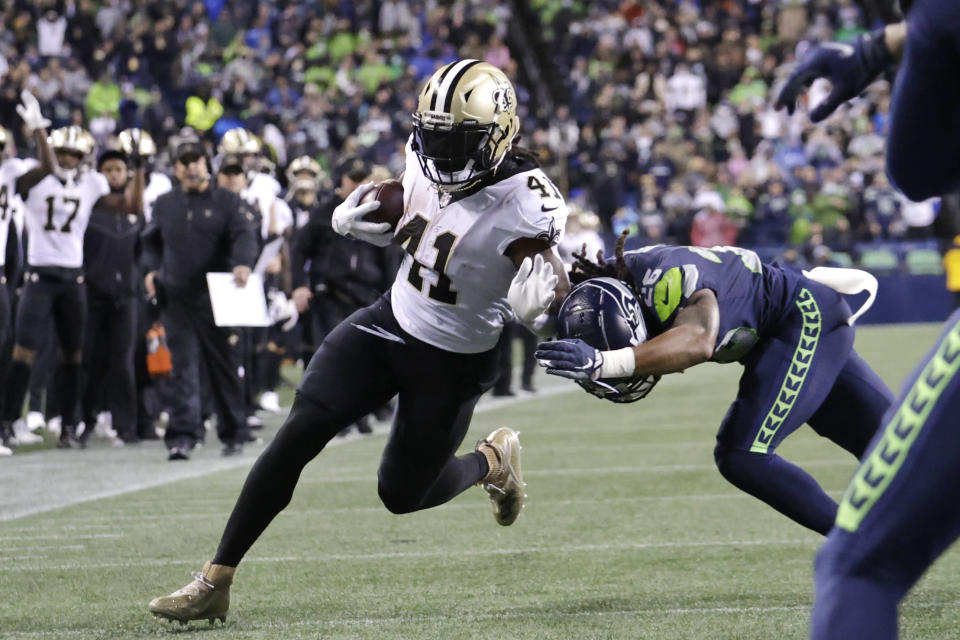 New Orleans Saints' Alvin Kamara runs for a touchdown after a pass reception as Seattle Seahawks' Ryan Neal defends during the first half of an NFL football game, Monday, Oct. 25, 2021, in Seattle. (AP Photo/John Froschauer)