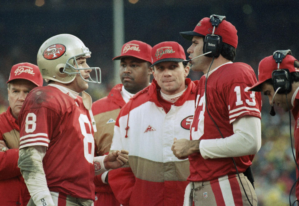 FILE - In this Jan. 18, 1993 file photo, San Francisco quarterbacks Steve Young, left, Joe Montana and Steve Bono, right; hold court along the sideline as time ran down in the Niners' 30-20 NFC championship loss to the Dallas Cowboys at Candlestick Park in San Francisco. Soon after the Super Bowl matchup was set, Hall of Famer Joe Montana went to Twitter to send out a picture of his framed jerseys for the Kansas City Chiefs and the San Francisco 49ers. Montana won four Super Bowl titles in 14 years with the 49ers before finishing his career with two seasons on the Chiefs when he made one trip to the AFC championship game. (AP Photo/Paul Sakuma, File)