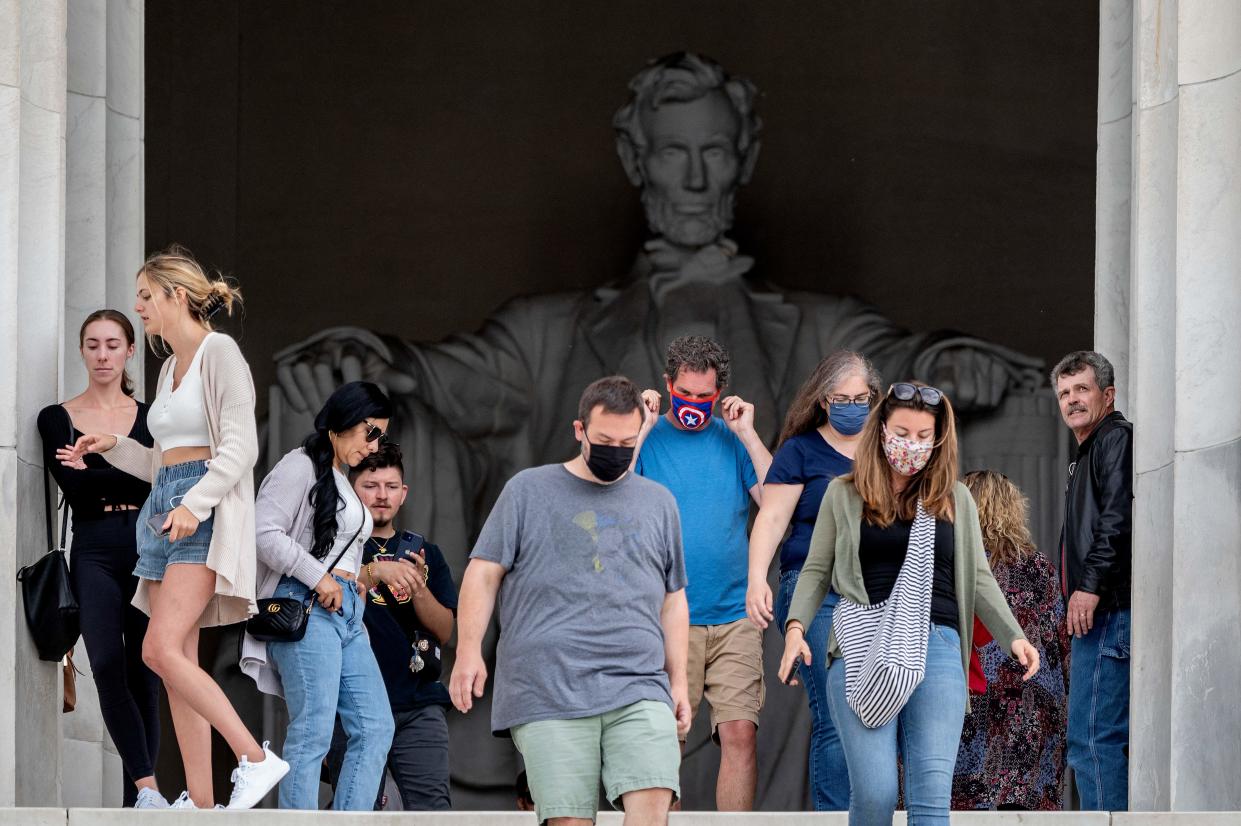 Tourists, some in face masks while others are not, visit the Lincoln Memorial in Washington, DC, on May 14, 2021. (Jim Watson/AFP via Getty Images)
