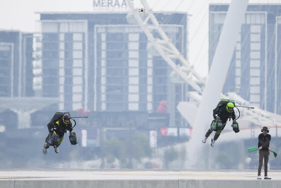 Jet suit pilots race in Dubai, United Arab Emirates, Wednesday, Feb. 28, 2024. Dubai on Wednesday hosted what it called its first-ever jet suit race. Racers zipped along a route with the skyscrapers of Dubai Marina looming behind them, controlling the jet engines on their hands and their backs. (AP Photo/Jon Gambrell)