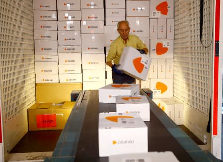 An employee places parcels of online mail order company Zalando on a conveyor at the parcel distribution center of Swiss Post in Frauenfeld